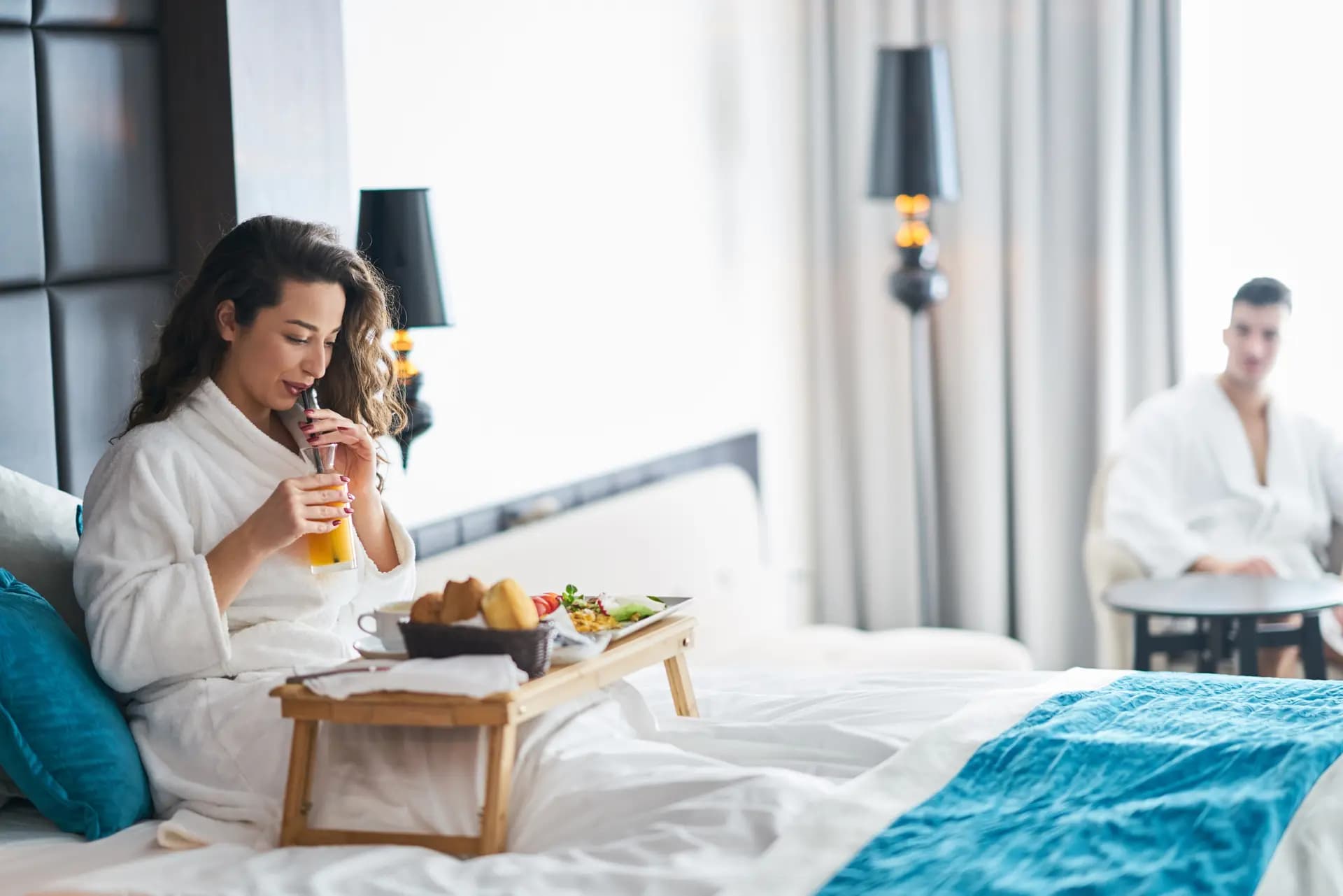 Couple enjoying breakfast in bed at a hotel